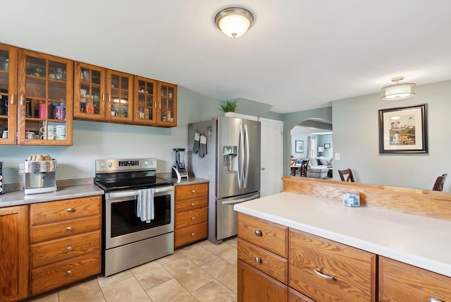 24 Ross Rd, Kennebunk, ME 04043 - kitchen with appliances with stainless steel finishes, brown cabinetry, arched walkways, and light countertops