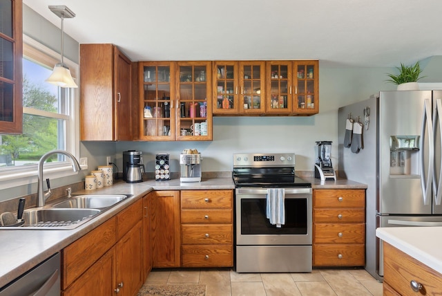 24 Ross Rd, Kennebunk, ME 04043 - kitchen featuring stainless steel appliances, brown cabinets, a sink, hanging light fixtures, and glass insert cabinets