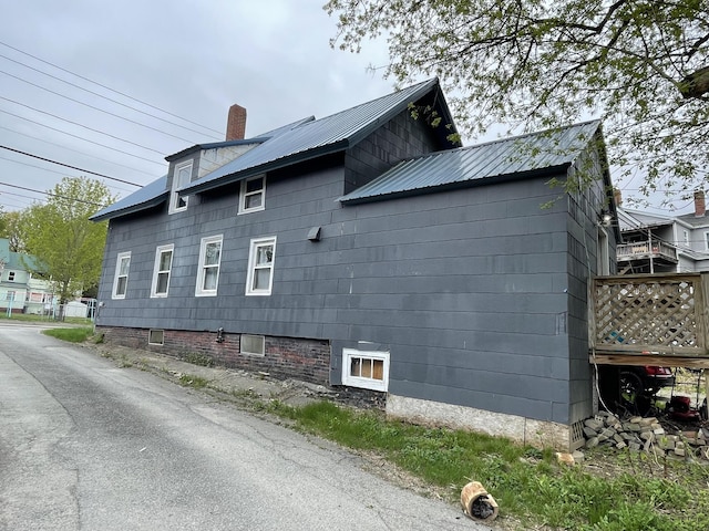 view of home's exterior with metal roof and a chimney
