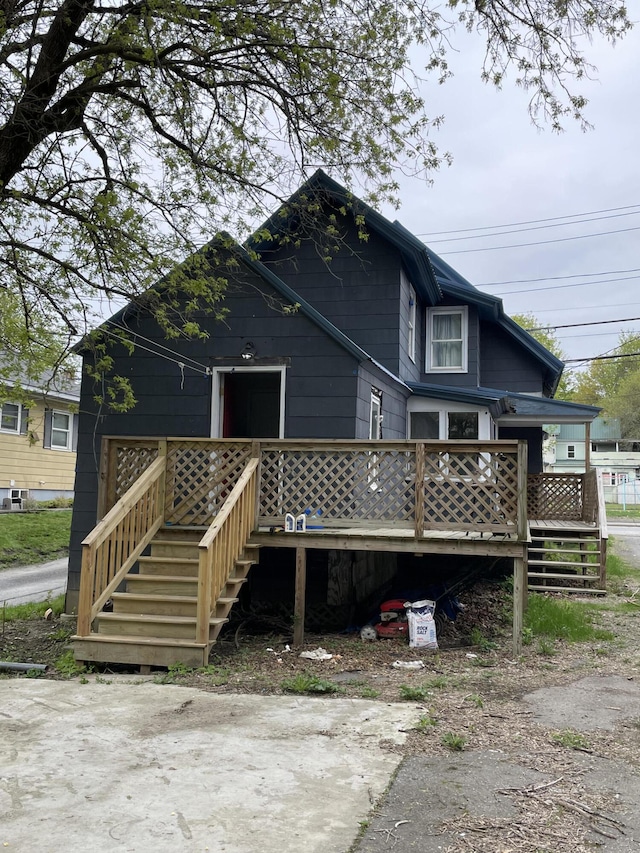 rear view of house featuring a wooden deck and stairs