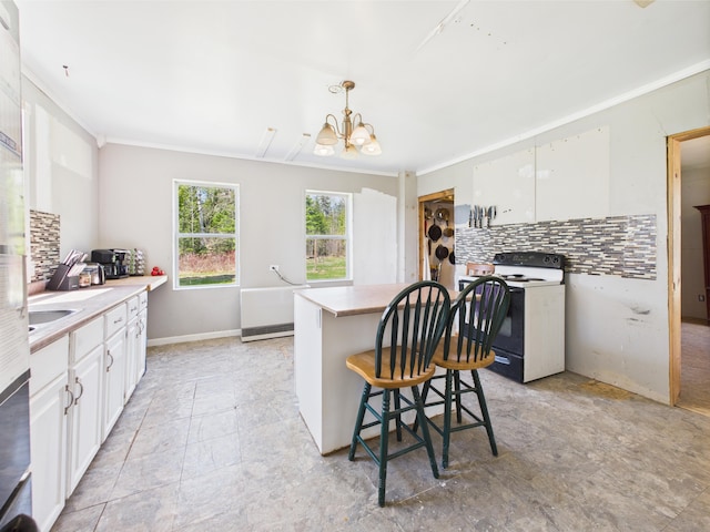 60 Carson Rd, Perham, ME 04766 - kitchen featuring a kitchen bar, white cabinets, electric range oven, backsplash, and a chandelier