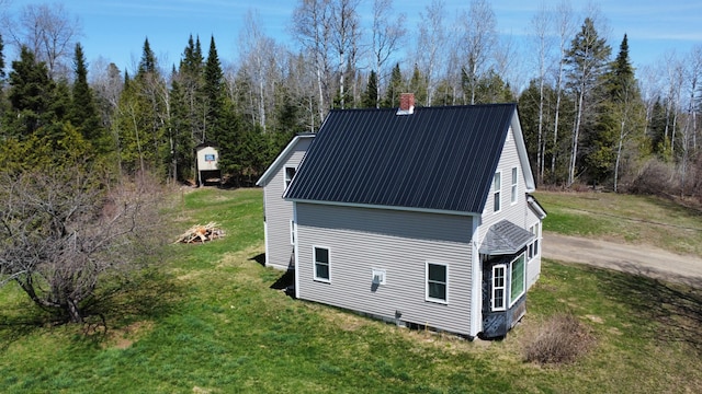 60 Carson Rd, Perham, ME 04766 - view of property exterior featuring metal roof, a forest view, a chimney, and a lawn