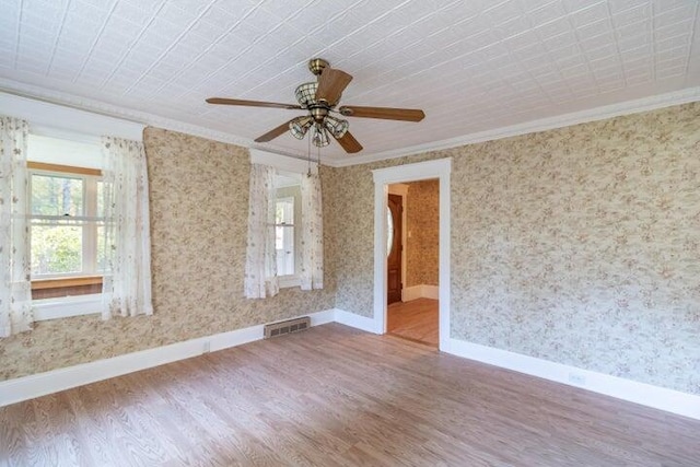 753 Sebec Village Rd, Sebec, ME 04481 - unfurnished room featuring ornamental molding, wood finished floors, healthy amount of natural light, baseboards, and wallpapered walls