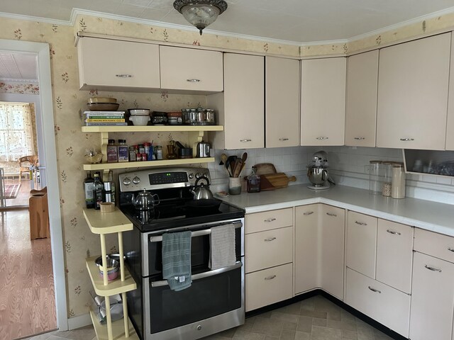 753 Sebec Village Rd, Sebec, ME 04481 - kitchen with double oven range, light countertops, ornamental molding, wallpapered walls, and backsplash