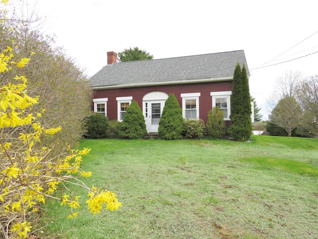 view of front of property with a chimney, entry steps, brick siding, and a front lawn