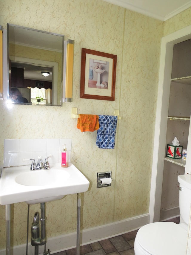 bathroom with crown molding and toilet