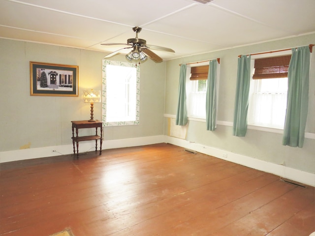 unfurnished room with ceiling fan, visible vents, and hardwood / wood-style floors