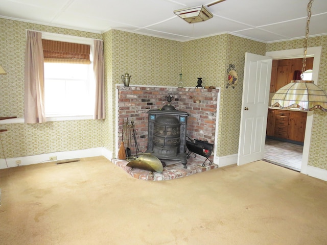 carpeted living room with a wood stove, wallpapered walls, and crown molding
