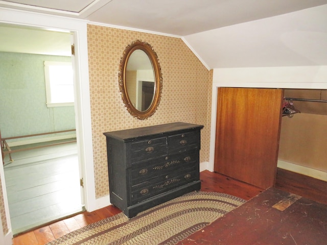 bedroom with baseboards, lofted ceiling, ornamental molding, and hardwood / wood-style flooring