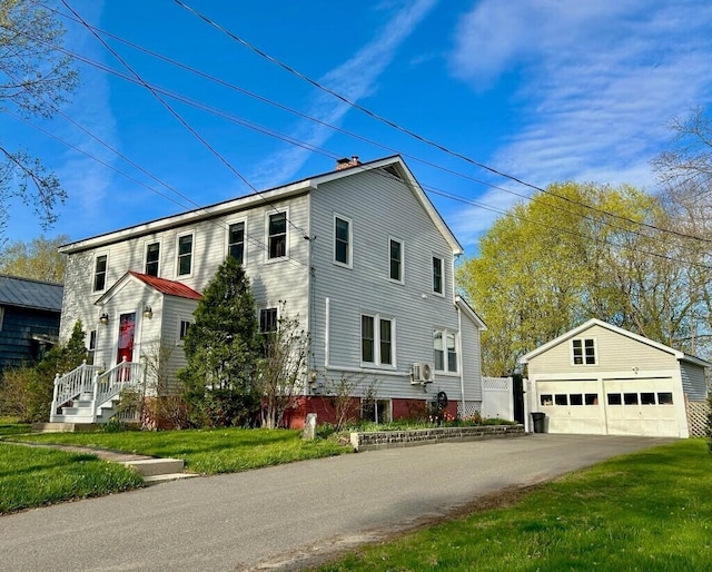 view of side of property featuring an outbuilding, a detached garage, and a lawn