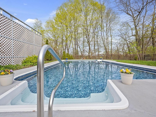 view of swimming pool with a fenced backyard and a sink