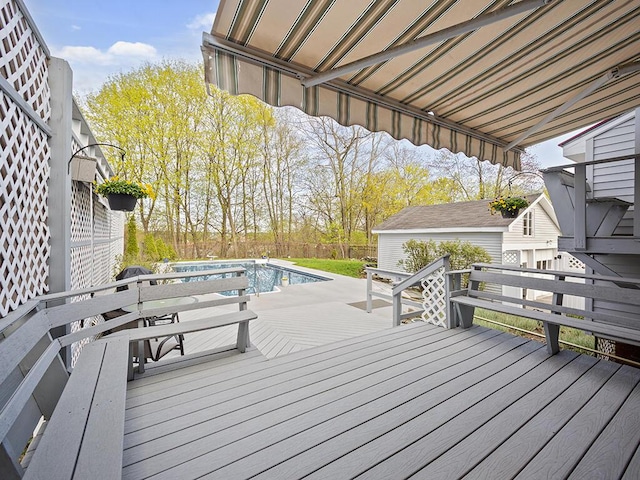 wooden terrace with an outdoor pool and fence