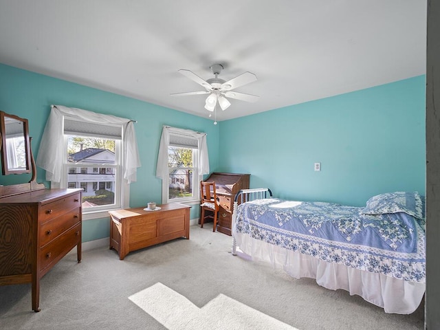 bedroom featuring light carpet, ceiling fan, and baseboards