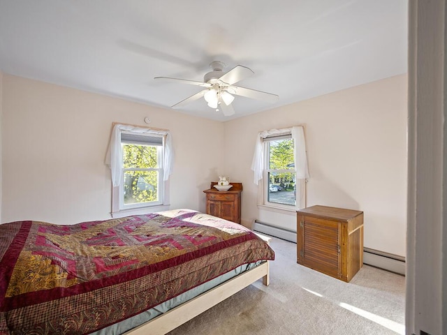 bedroom with a baseboard heating unit, carpet floors, and ceiling fan