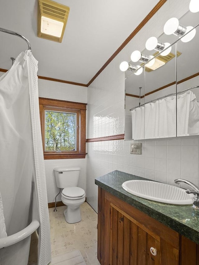 bathroom with tile walls, toilet, vanity, crown molding, and tile patterned floors