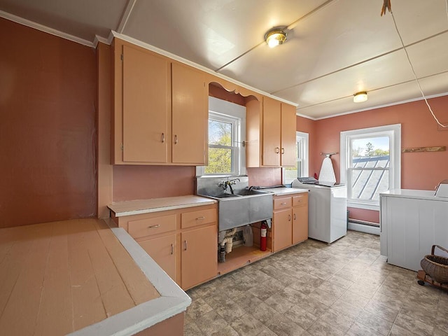 kitchen with light countertops, crown molding, a baseboard radiator, and washer and dryer