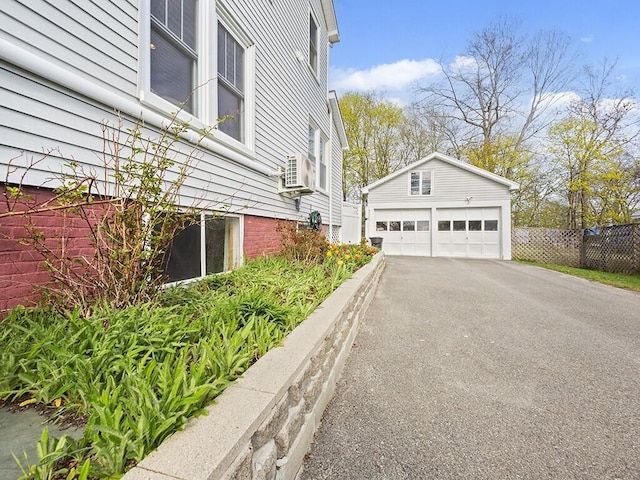 view of side of property featuring an outbuilding, a detached garage, and fence