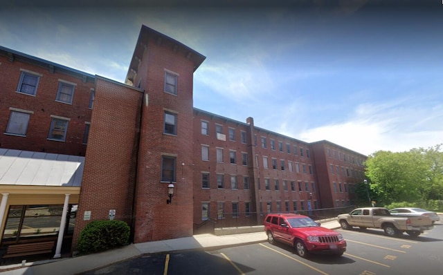 view of apartment building / complex featuring uncovered parking