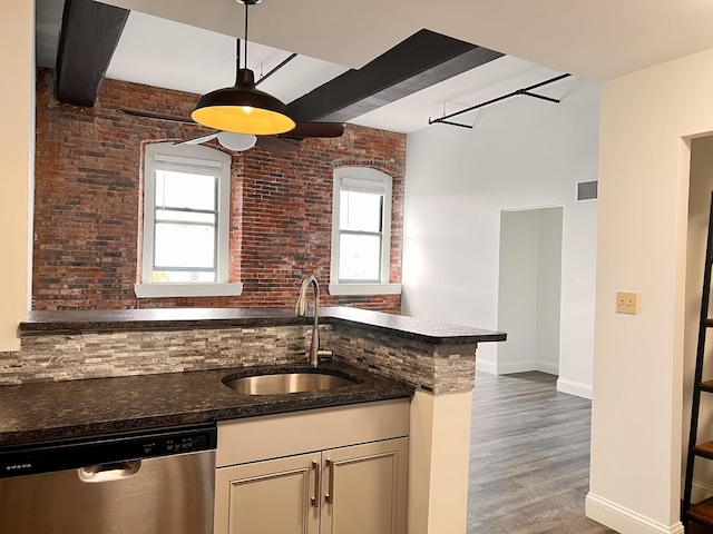 1 Saco Island Ter Unit 205, Saco, ME 04072 - kitchen with stainless steel dishwasher, a sink, healthy amount of natural light, dark stone countertops, and brick wall