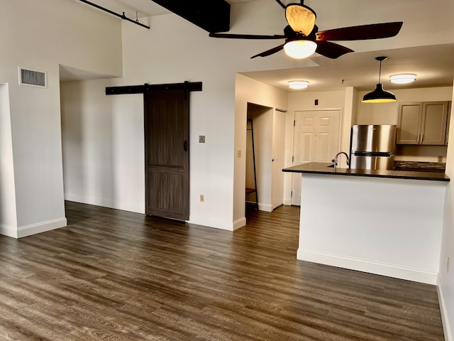 1 Saco Island Ter Unit 205, Saco, ME 04072 - kitchen with a barn door, freestanding refrigerator, dark countertops, ceiling fan, and baseboards