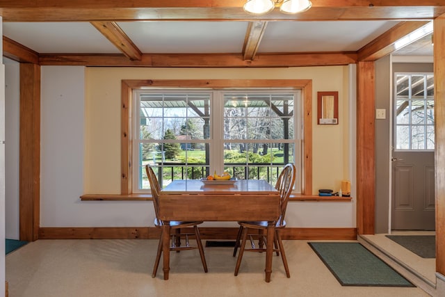 dining area with baseboards and beamed ceiling