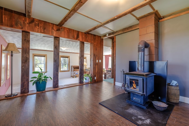 unfurnished living room featuring a wood stove and wood finished floors