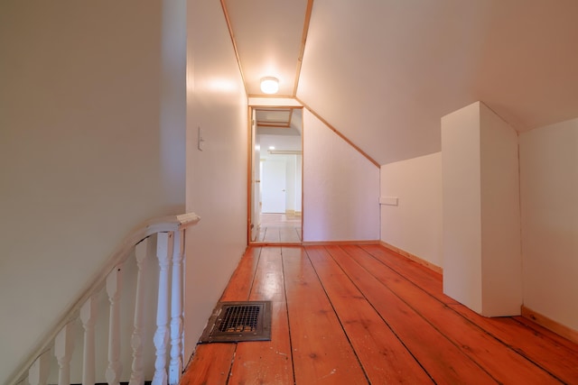 additional living space featuring vaulted ceiling, visible vents, and light wood-style floors