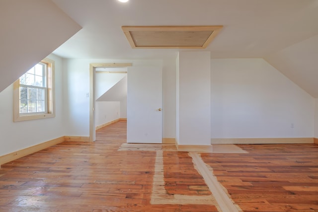 bonus room with lofted ceiling, recessed lighting, attic access, baseboards, and hardwood / wood-style flooring