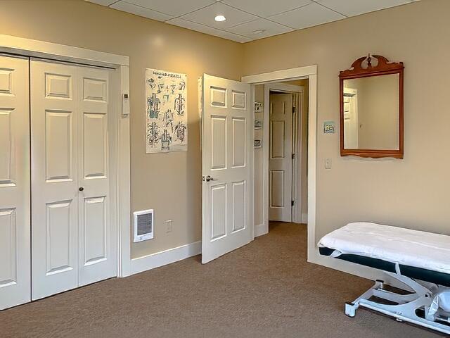 bedroom with a closet, visible vents, carpet floors, a paneled ceiling, and baseboards