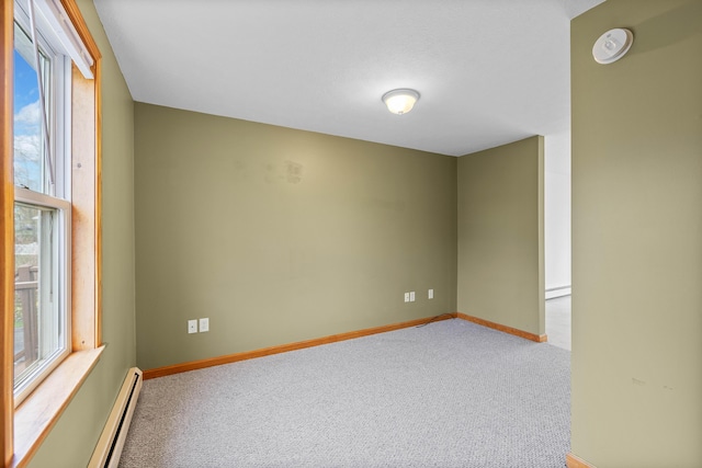 carpeted empty room featuring healthy amount of natural light, baseboard heating, and baseboards