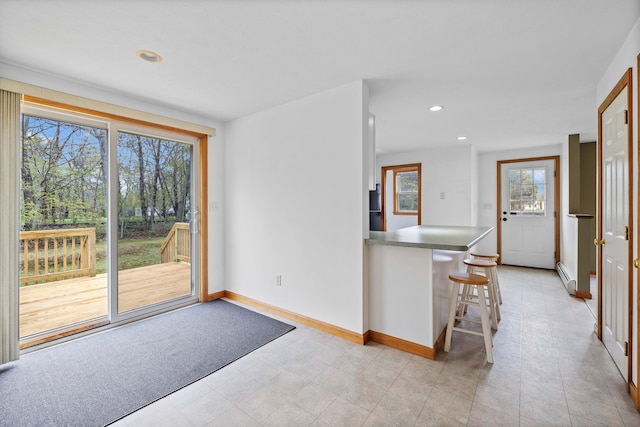 entryway featuring a baseboard radiator, baseboards, and recessed lighting