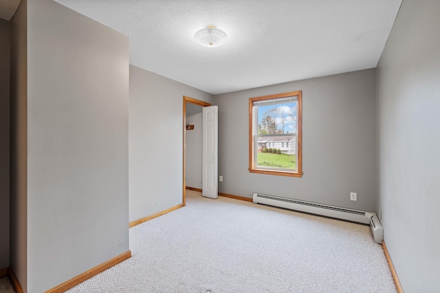 carpeted empty room with baseboard heating and baseboards