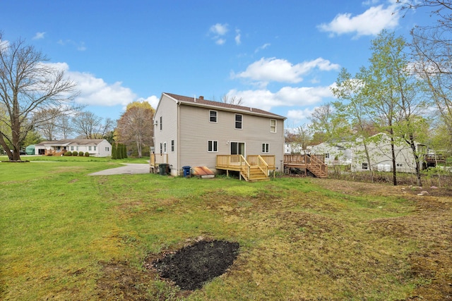 back of house with a deck, a yard, and stairway