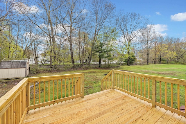 deck featuring a storage shed, an outbuilding, and a lawn