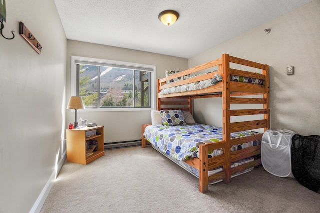 carpeted bedroom featuring baseboard heating, a textured ceiling, and baseboards