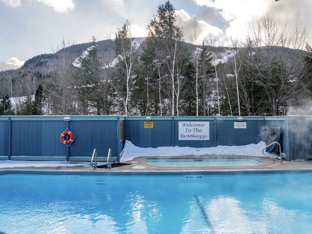 community pool featuring a mountain view and a community hot tub
