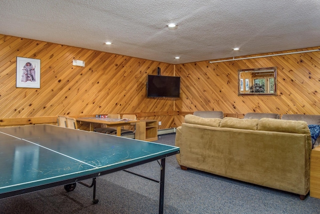 recreation room with a baseboard heating unit, carpet, a textured ceiling, recessed lighting, and wooden walls
