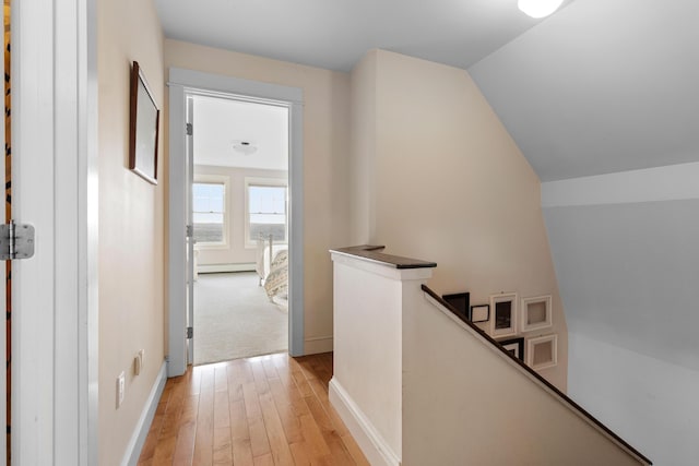 83 Barrett Hill Rd, Hope, ME 04847 - hallway with an upstairs landing, light wood-style floors, a baseboard heating unit, baseboards, and lofted ceiling