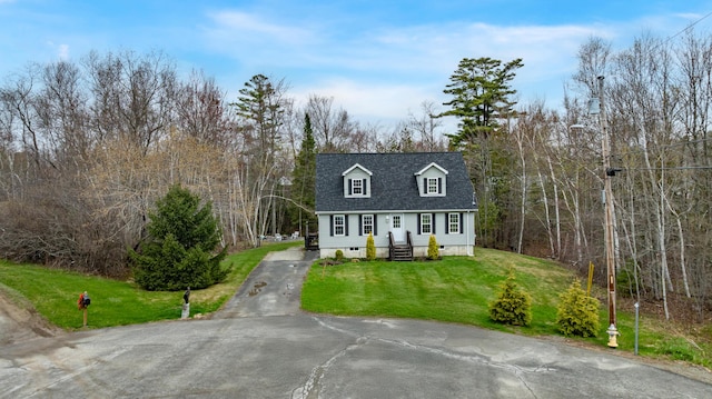 new england style home featuring a front yard and aphalt driveway