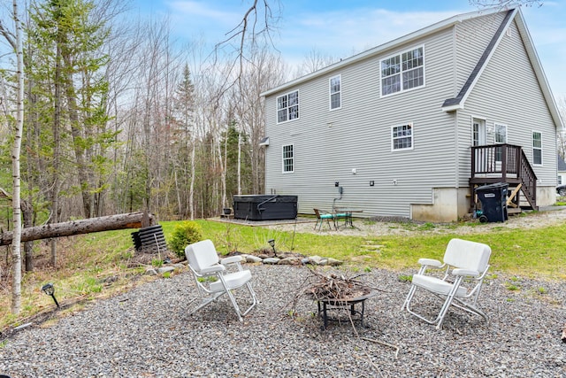 back of house featuring a fire pit and a hot tub