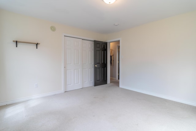 unfurnished bedroom featuring a closet, baseboards, and carpet floors