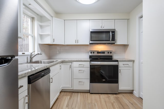 3 Great Pond Ter Unit 3, Cape Elizabeth, ME 04107 - kitchen featuring a sink, open shelves, backsplash, stainless steel appliances, and white cabinets