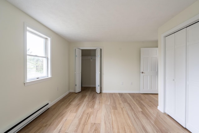 3 Great Pond Ter Unit 3, Cape Elizabeth, ME 04107 - unfurnished bedroom featuring a baseboard radiator, baseboards, two closets, and light wood-style floors