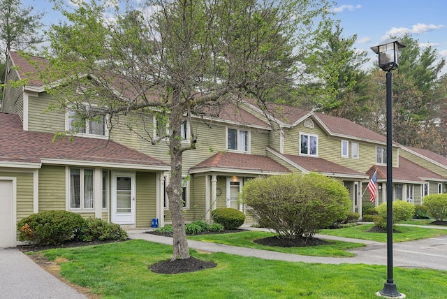 view of front of property featuring a front yard and roof with shingles