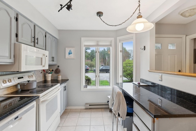 kitchen featuring white appliances, baseboard heating, plenty of natural light, and light tile patterned floors