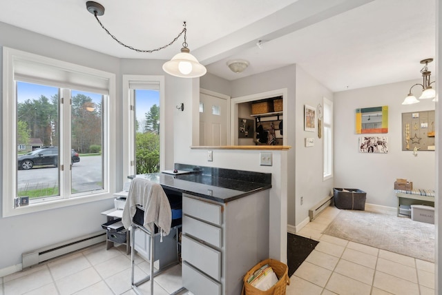 kitchen with a baseboard heating unit, an office area, light tile patterned flooring, and pendant lighting