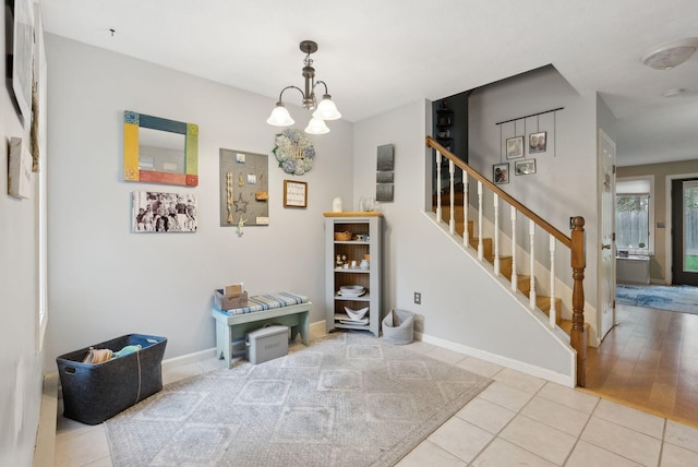 dining space featuring stairs, tile patterned floors, a chandelier, and baseboards