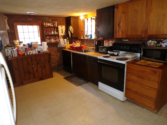17 Kingsbury Rd, Wellington, ME 04942 - kitchen featuring range with electric cooktop, stainless steel microwave, a sink, light floors, and brown cabinets