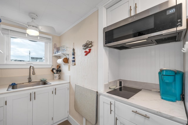 273 Webhannet Dr Unit 8, Wells, ME 04090 - kitchen with stainless steel microwave, a sink, ornamental molding, white cabinets, and black electric cooktop