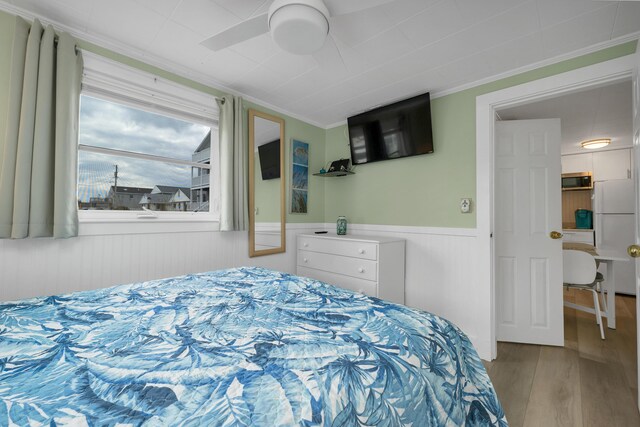 273 Webhannet Dr Unit 8, Wells, ME 04090 - bedroom featuring wood finished floors, freestanding refrigerator, wainscoting, ornamental molding, and a ceiling fan
